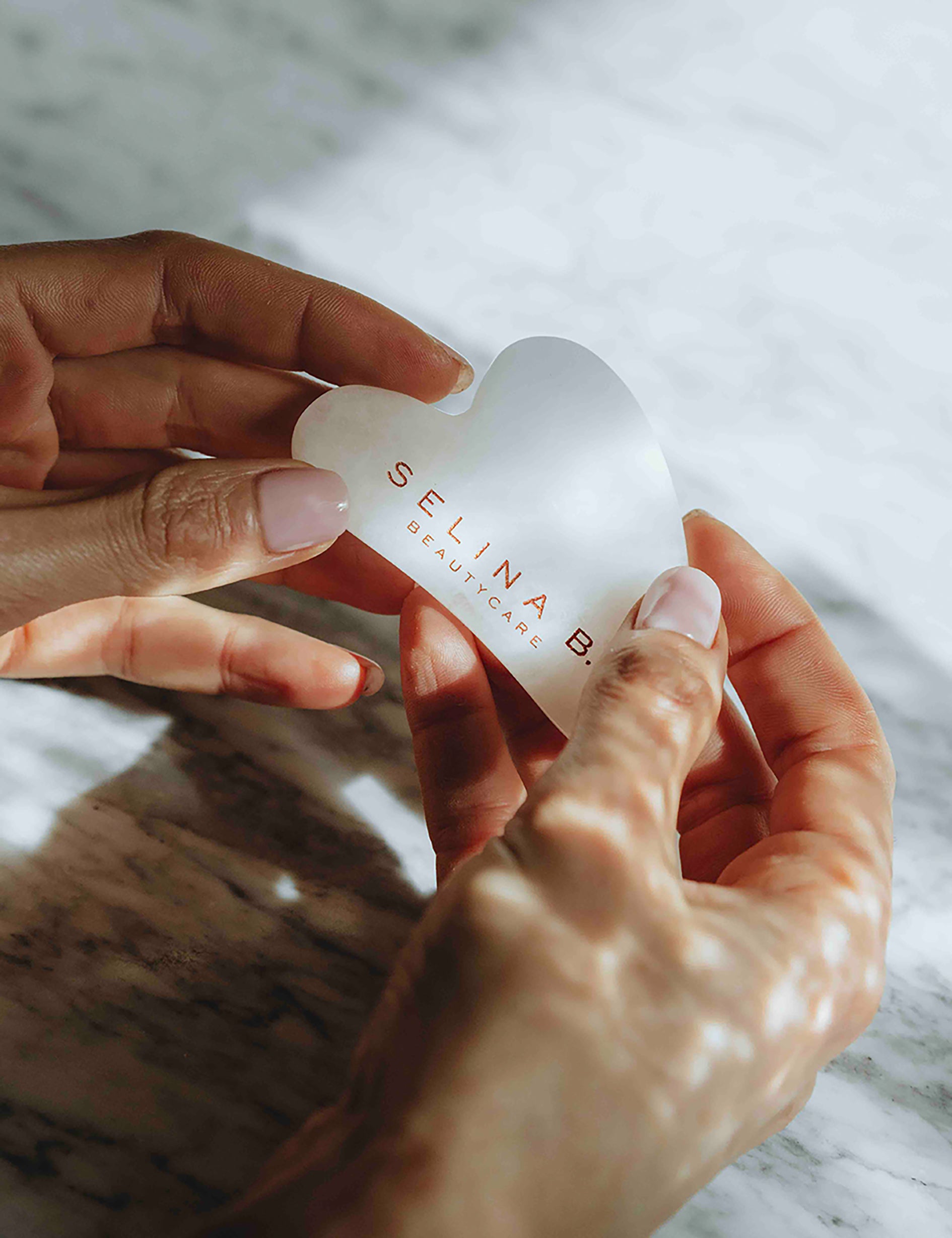Gua_Sha_white_Jade_stone_in_Hands.jpg